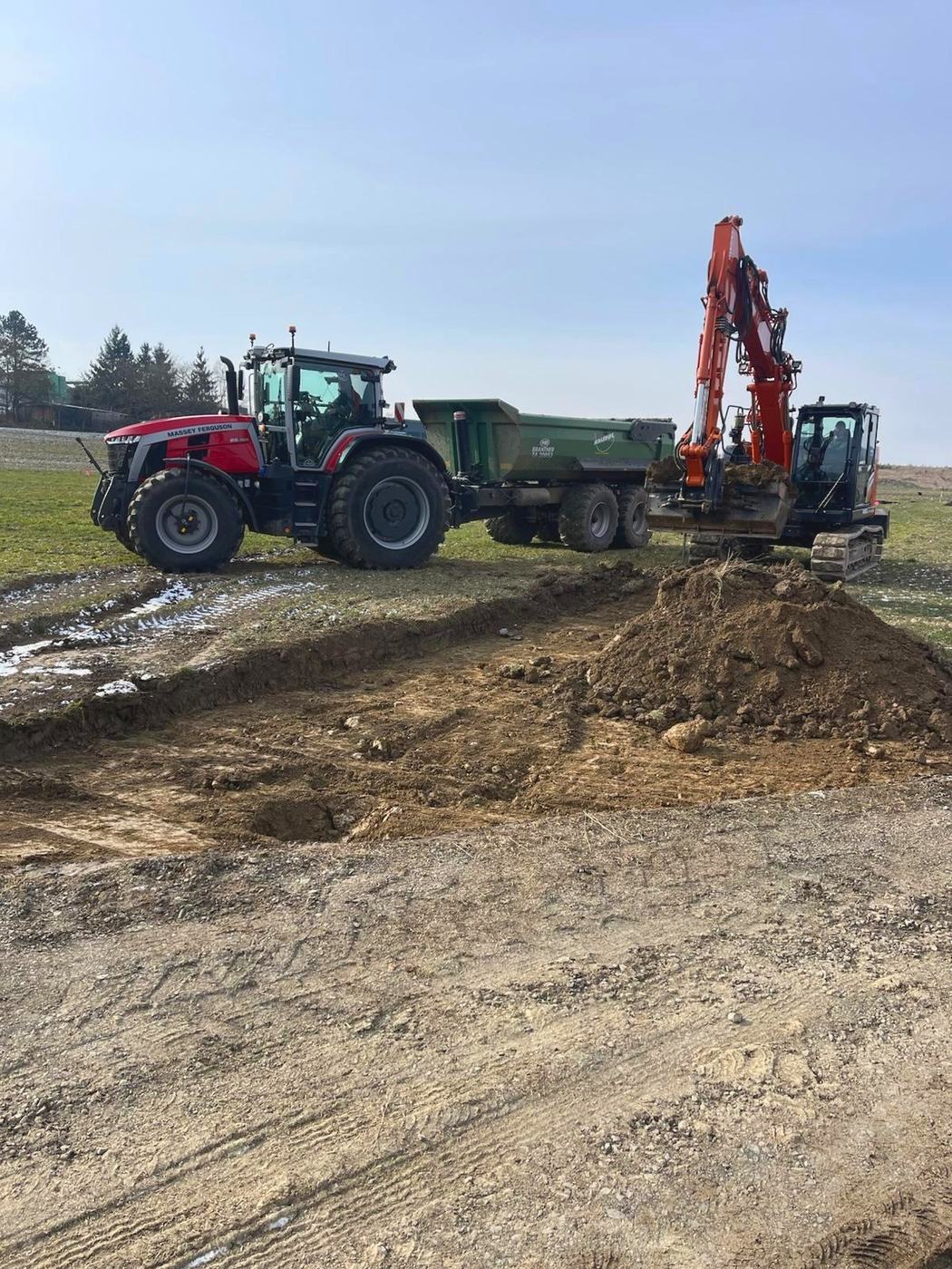 Bagger verlädt Erdreich auf einen Anhänger
