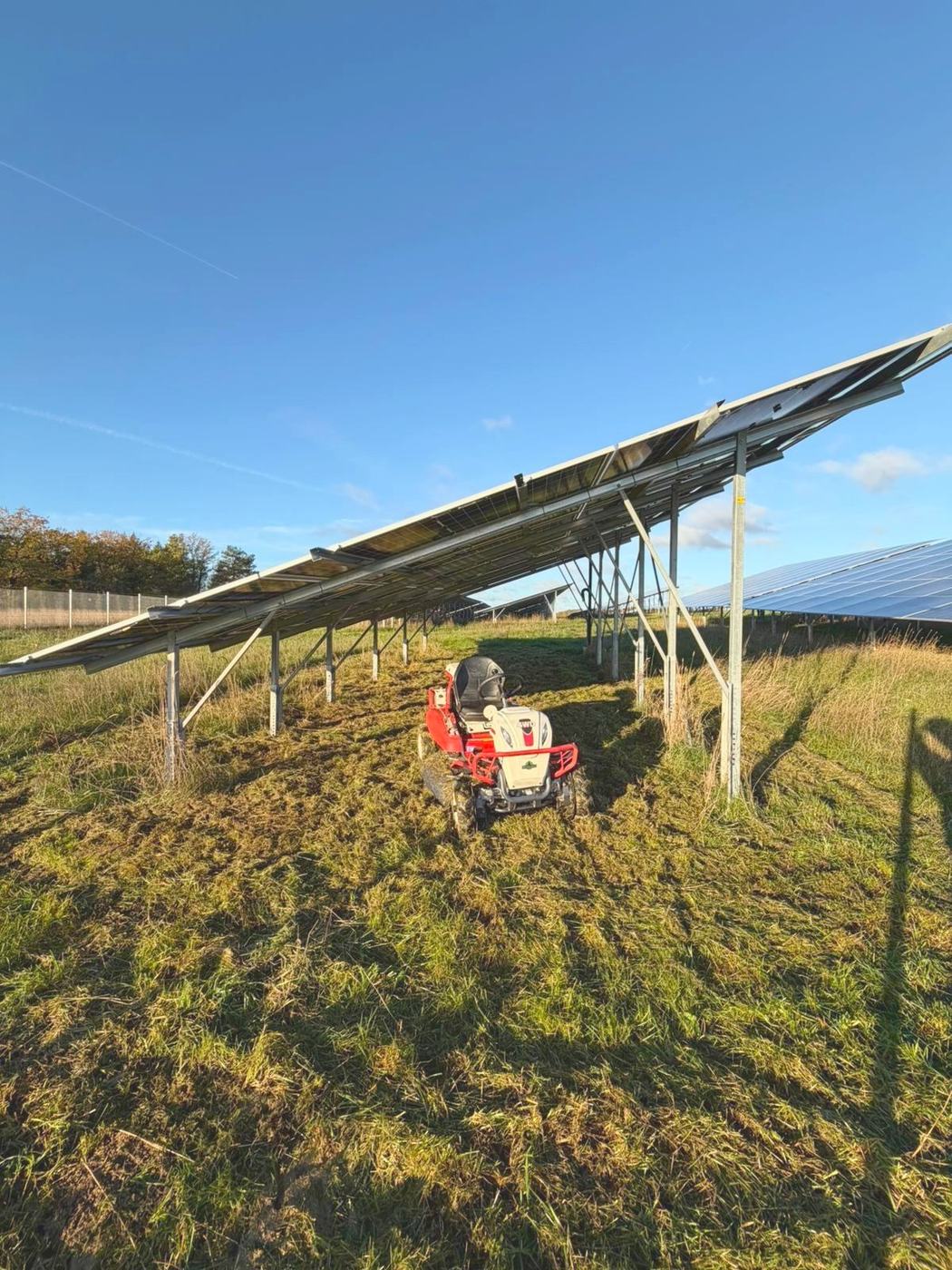Mäharbeiten unter einer Photovoltaikanlage