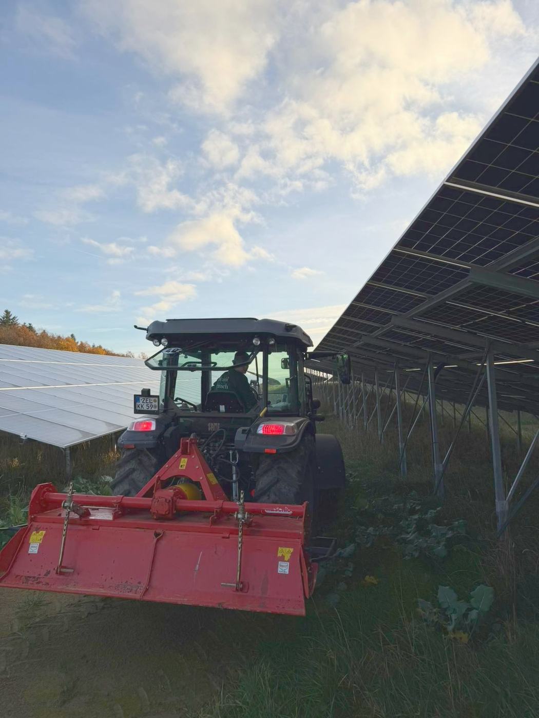 Traktor bei der Grünflächenpflege in einer Photovoltaikanlage